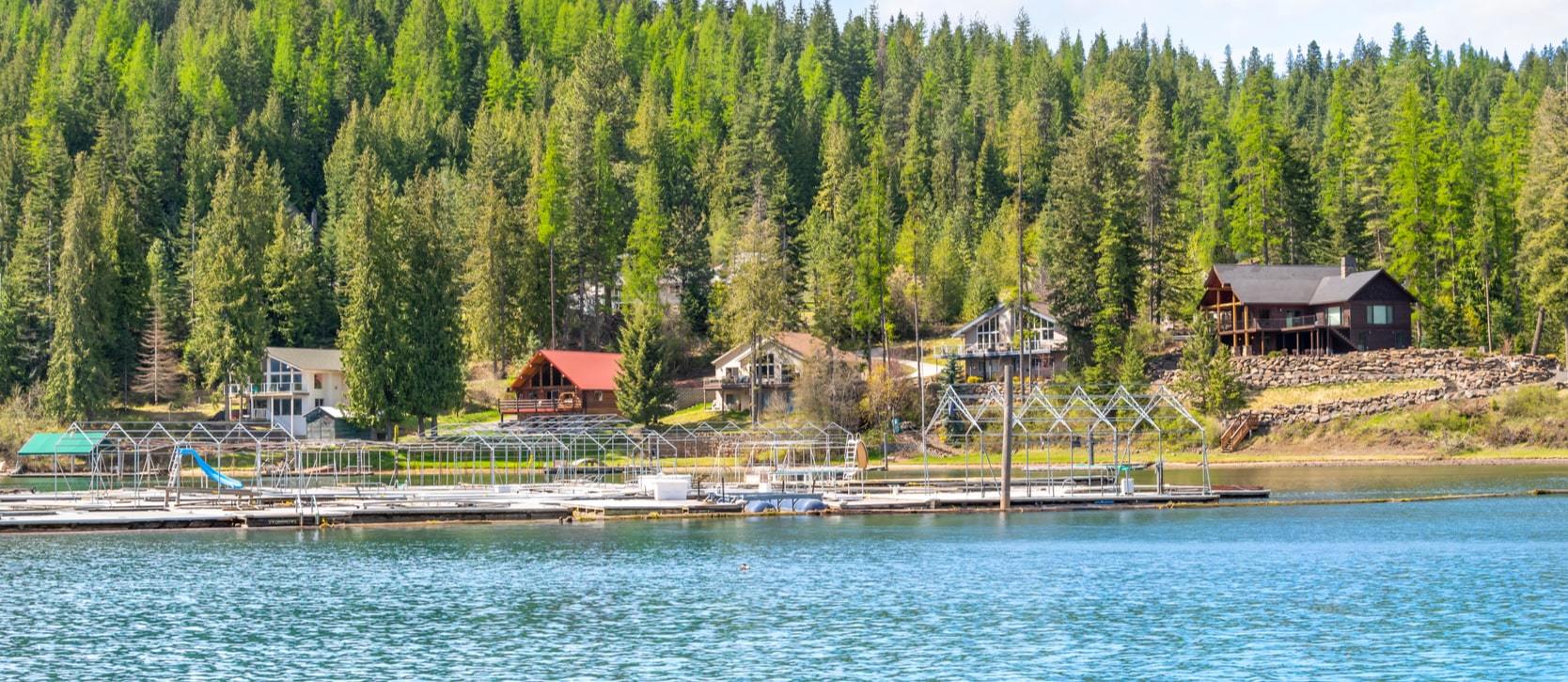 Houses on the lake with a forest backdrop near The Club At Black Rock in Coeur d'Alene